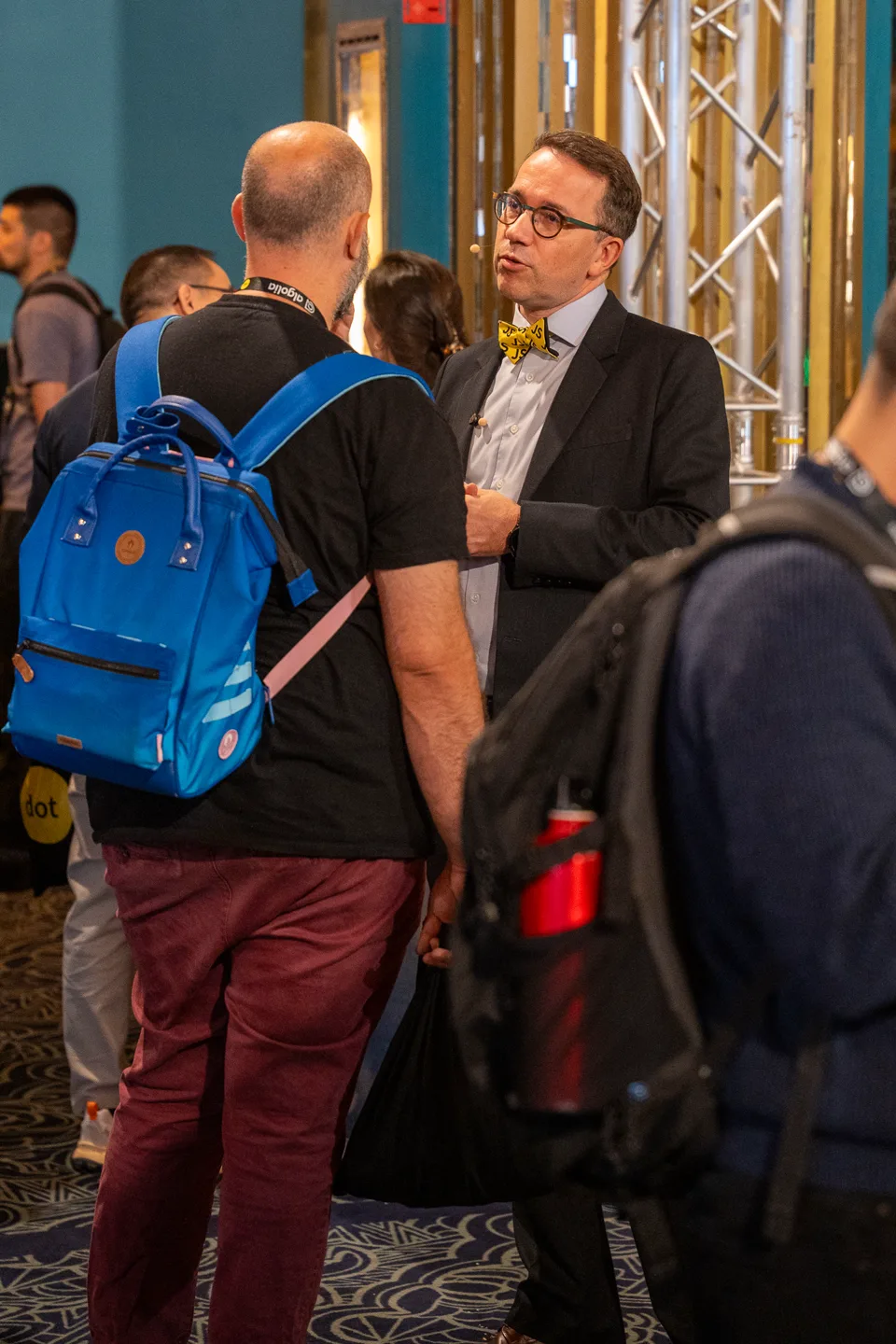 Deux participants échangent dans le salon, photographiés à proximité