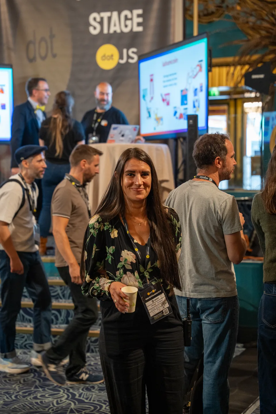 Une participante sourit face à l’objectif au milieu du salon dotJS